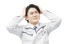 頭を抱えながら悩んでいる様子の男性の写真