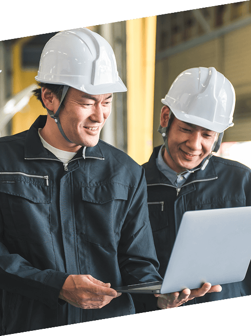 ヘルメットを着用した作業員がノートパソコンでデータを確認している現場風景